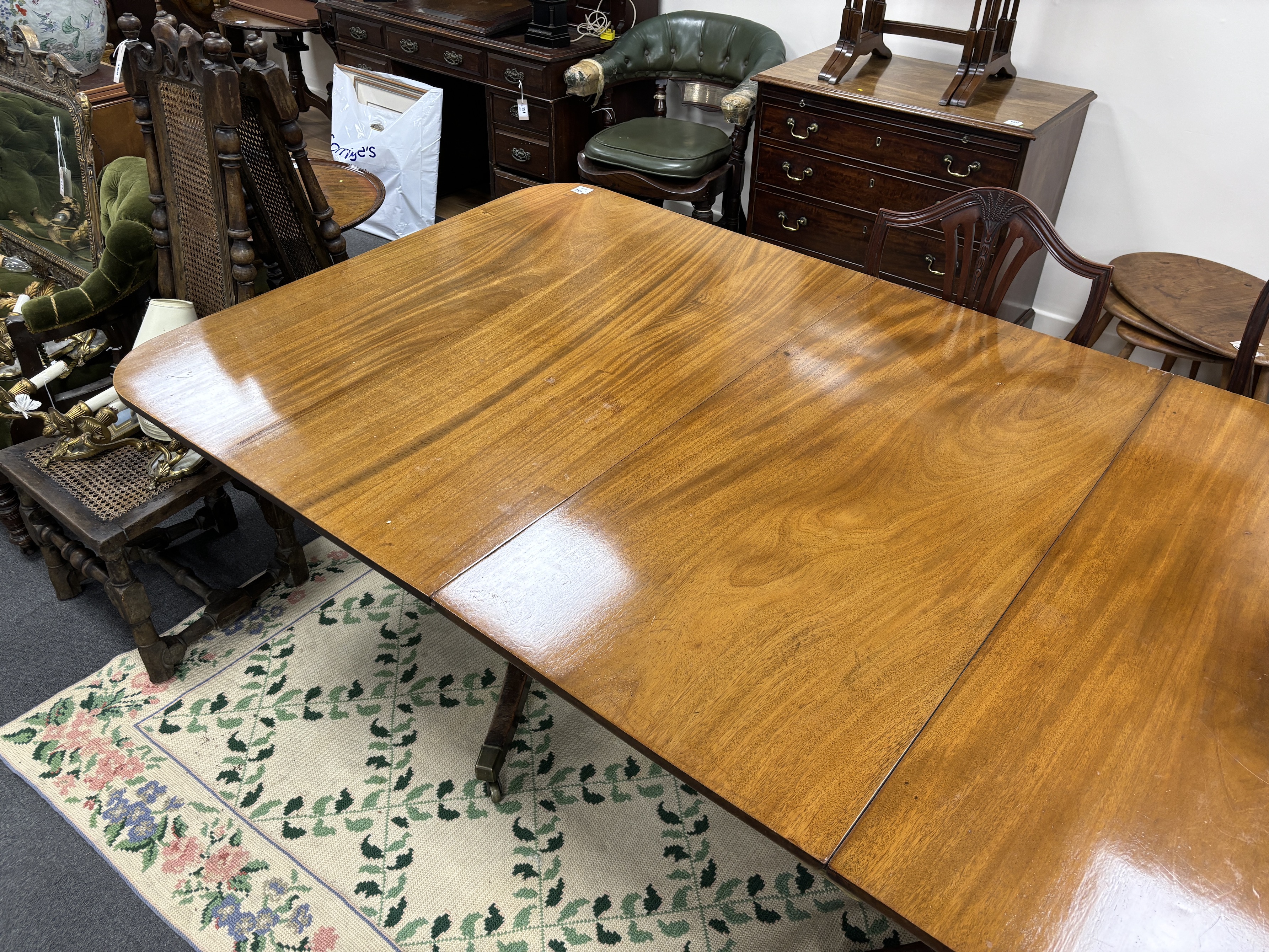 A George III style mahogany triple pillar extending dining table, 346cm extended, two spare leaves, depth 118cm, height 75cm